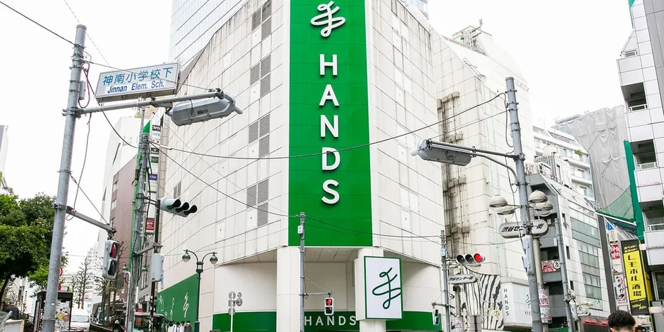 Magasin 'Hands' dans un bâtiment moderne avec panneaux verts.