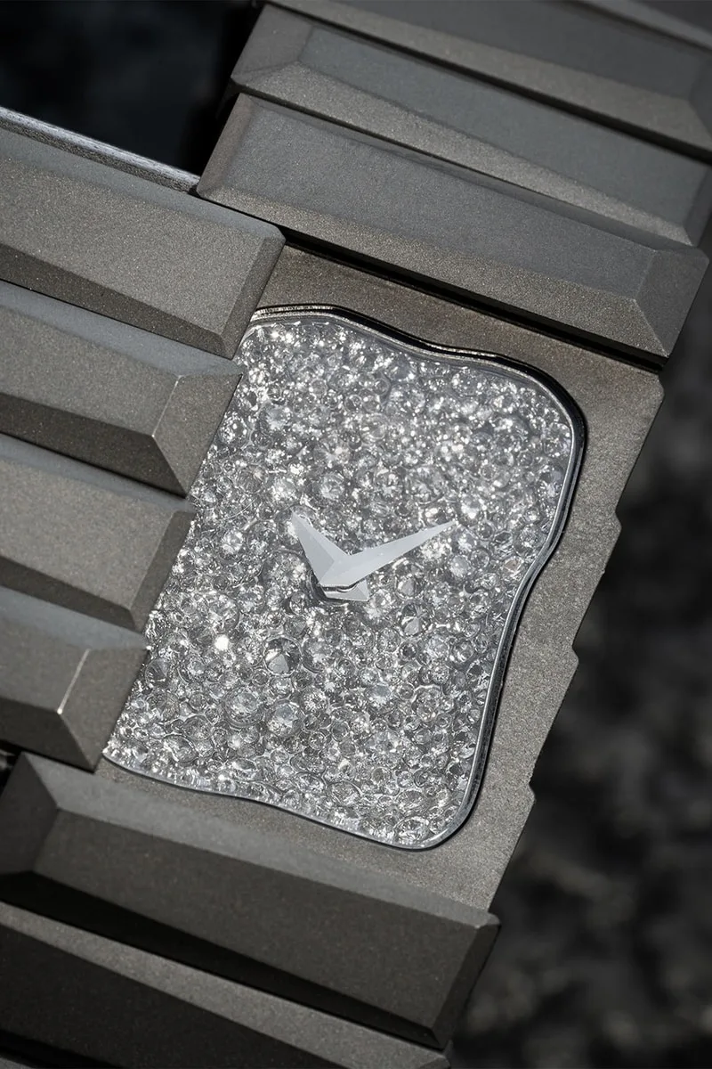 Montre luxueuse avec un cadran étincelant de cristaux et un bracelet en métal sculpté.