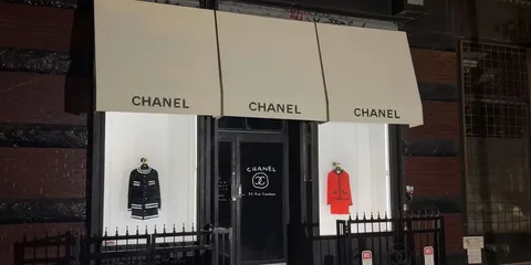 Devanture de boutique Chanel avec vêtements exposés, nuit.