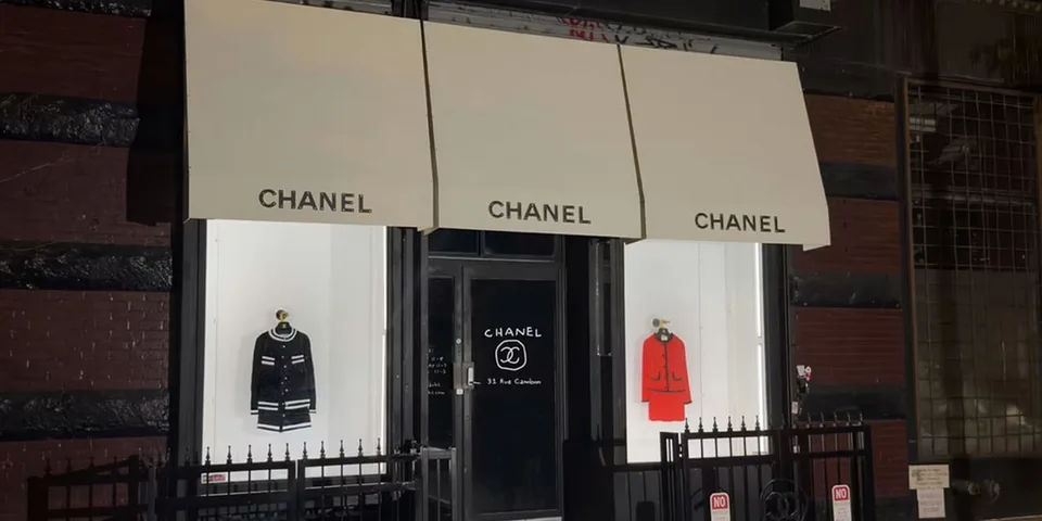 Devanture de boutique Chanel avec vêtements exposés, nuit.