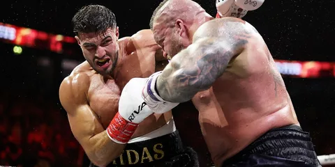 Deux boxeurs s'affrontent sur le ring, l'un frappant l'autre.
