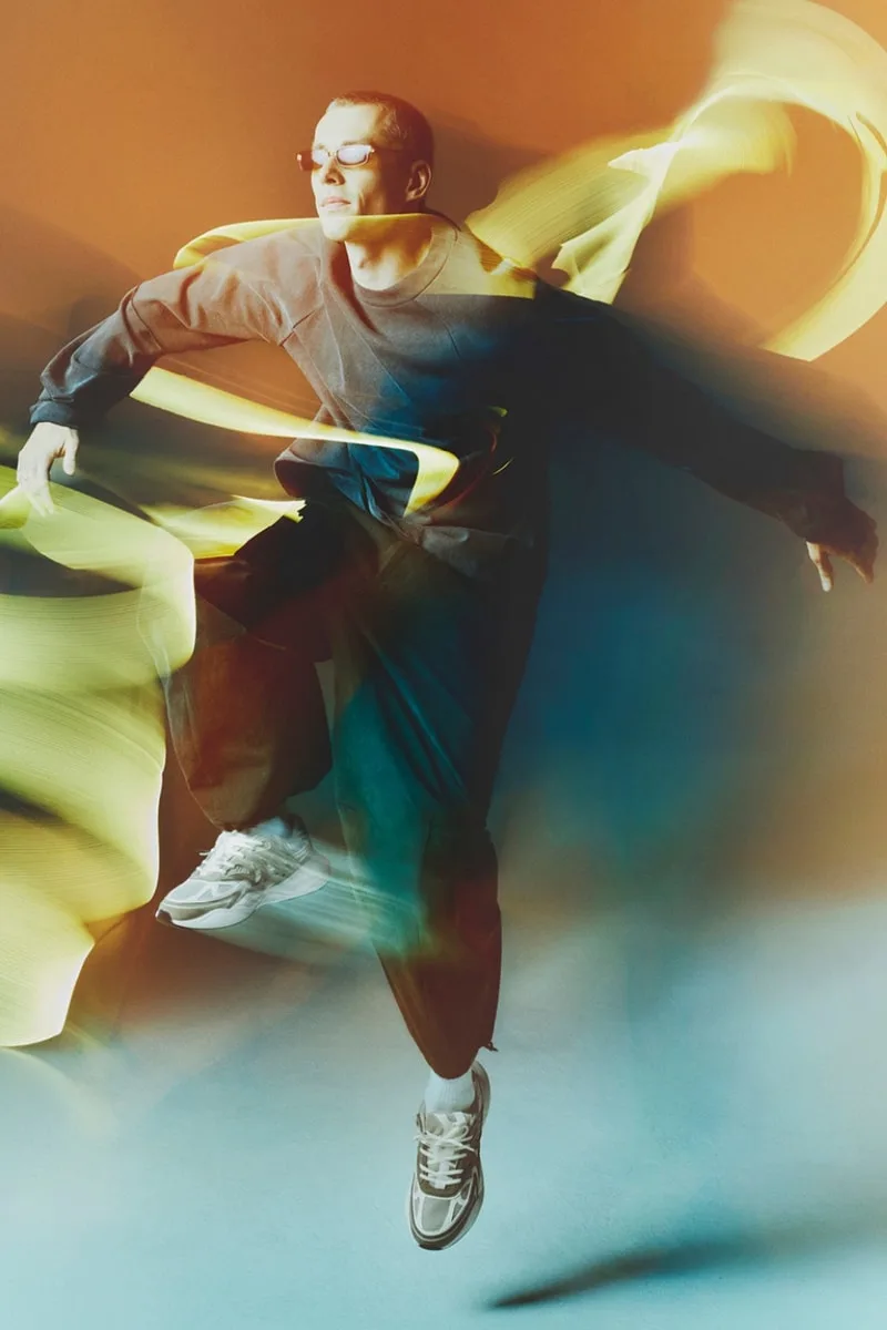 Homme en mouvement avec effets de lumière floues, fond coloré.