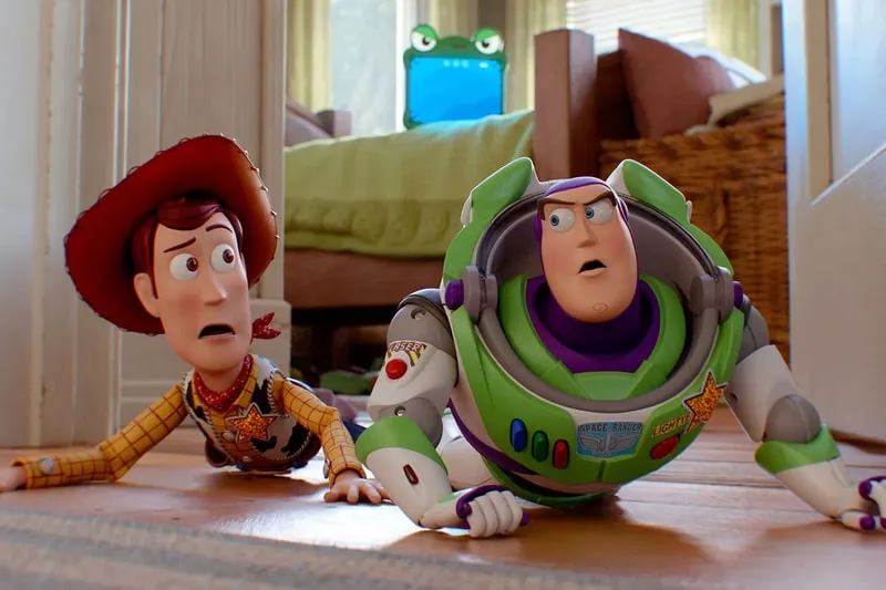 Deux jouets, un cow-boy et un astronaute, rampent dans une chambre.