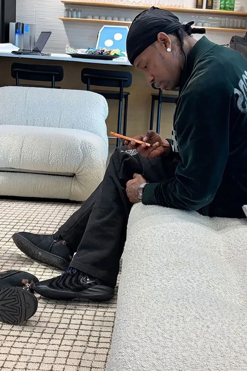 Homme assis sur un canapé, regardant son téléphone.