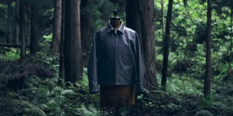 Mannequin avec veste en cuir dans la forêt verdoyante.
