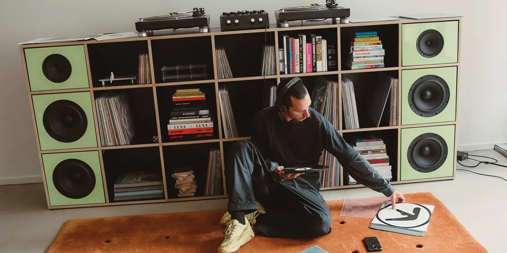 Homme écoutant de la musique, disques vinyles et tourne-disques dans une étagère.