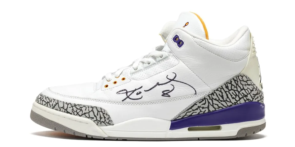 Chaussure blanche avec motifs gris et accent violet, signée au stylo.