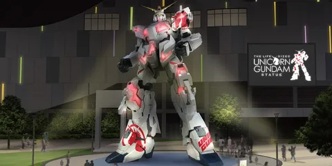 Statue grandeur nature du Gundam Unicorn illuminée la nuit.