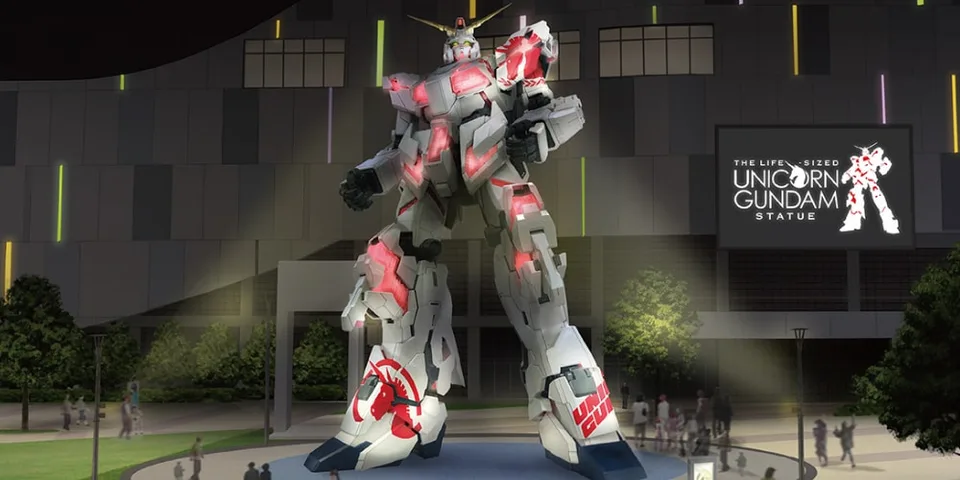 Statue grandeur nature du Gundam Unicorn illuminée la nuit.