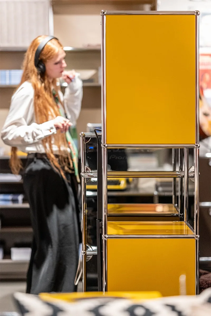 Femme aux cheveux longs écoute de la musique dans un magasin moderne.