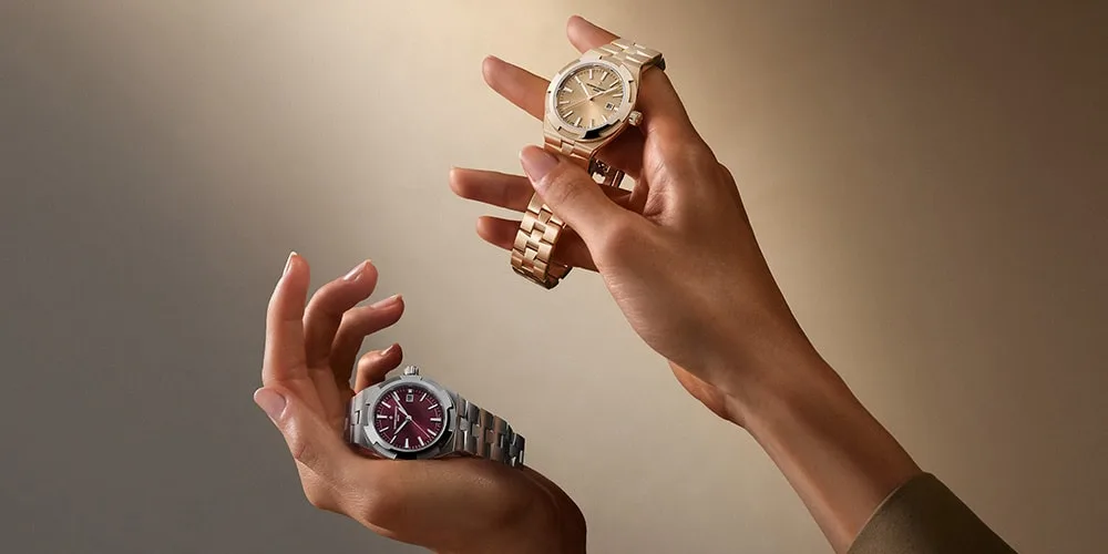 Deux montres au poignet, en métal doré et argenté, sur fond beige.