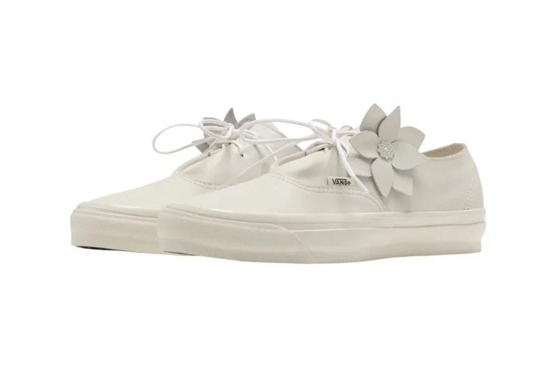 Chaussures blanches Vans avec décoration fleur sur les lacets.