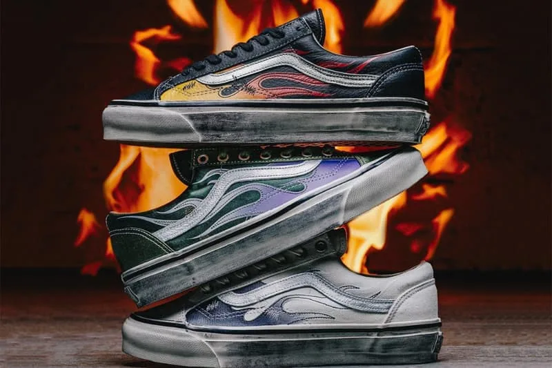 Trois paires de baskets colorées empilées devant des flammes.