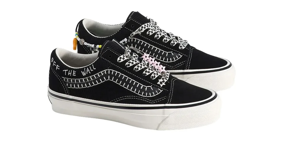 Chaussures noires avec détails blancs et ornements colorés.