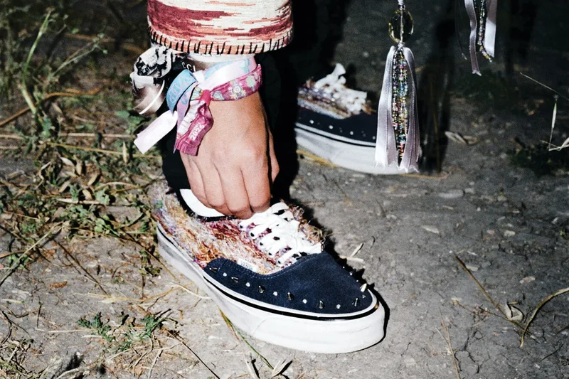 Personne attachant des chaussures colorées avec des décorations et bracelets.