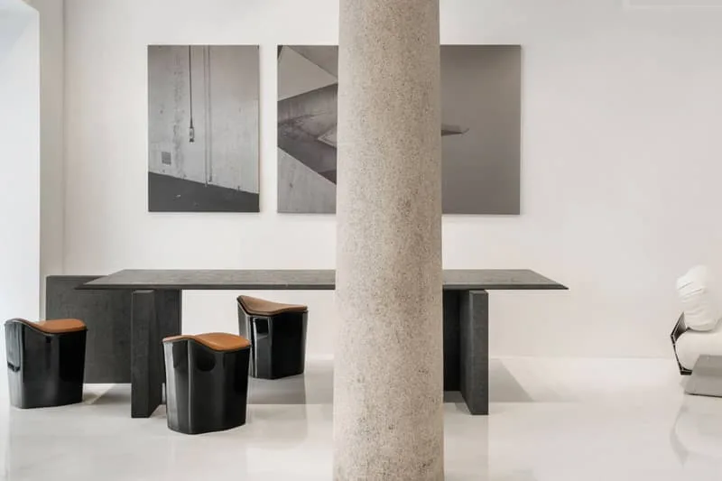 Intérieur moderne avec table, colonnes et œuvres d'art murales.
