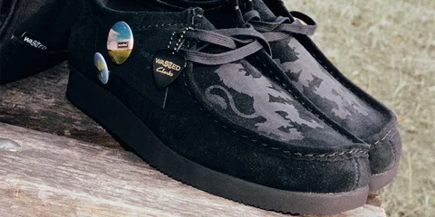 Chaussures en daim noir avec écussons et semelle épaisse.