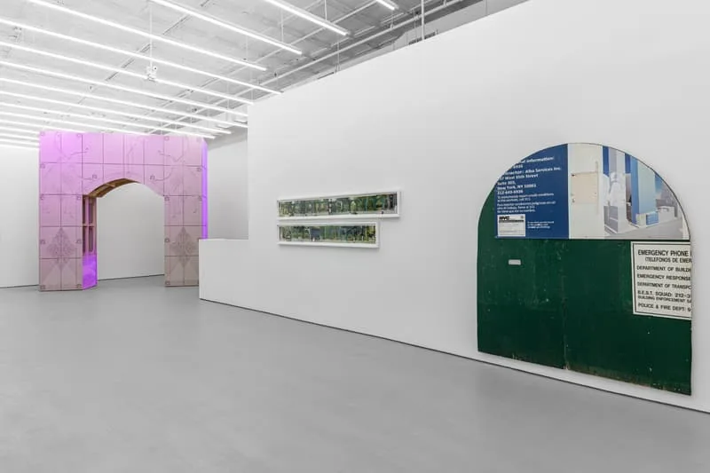 Exposition d'art moderne avec portes décoratives et panneaux lumineux.