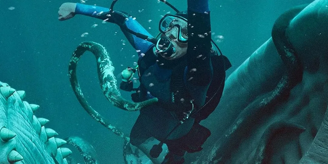 Un plongeur se bat avec un calamar géant sous l'eau.
