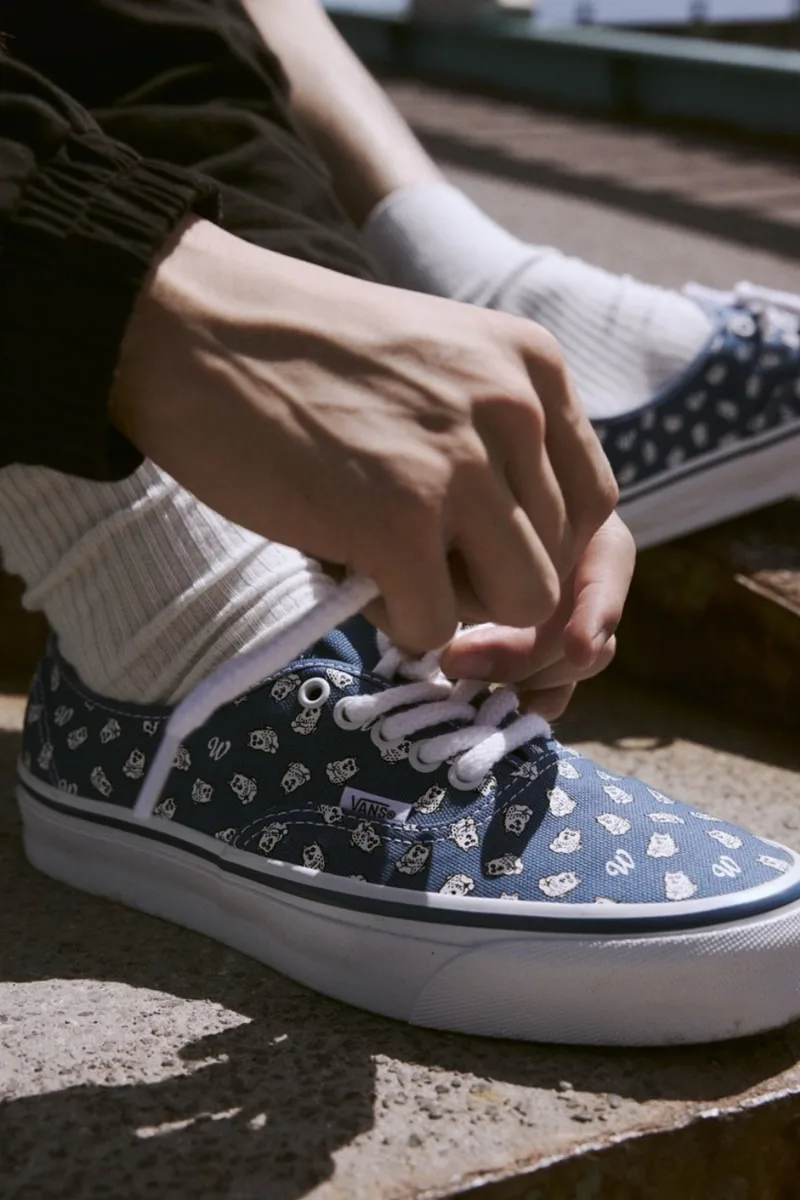 Personne lace des chaussures bleues avec motifs.