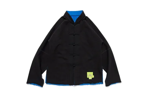 Veste noire avec coutures bleues et détails de nœuds.