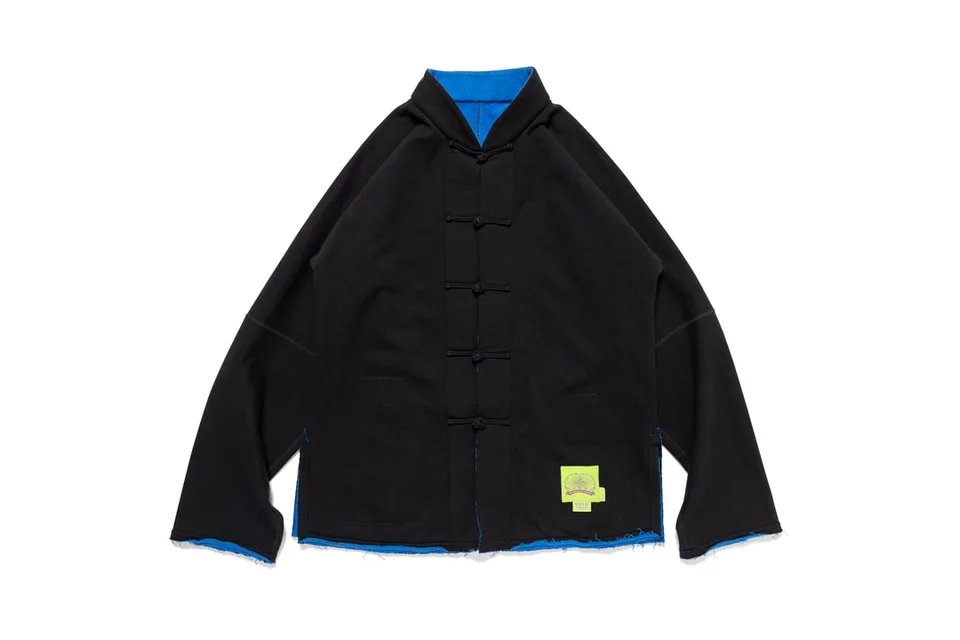 Veste noire avec coutures bleues et détails de nœuds.