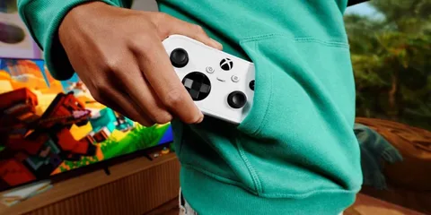 Personne tenant une manette Xbox blanche près d'un téléviseur avec jeu coloré.