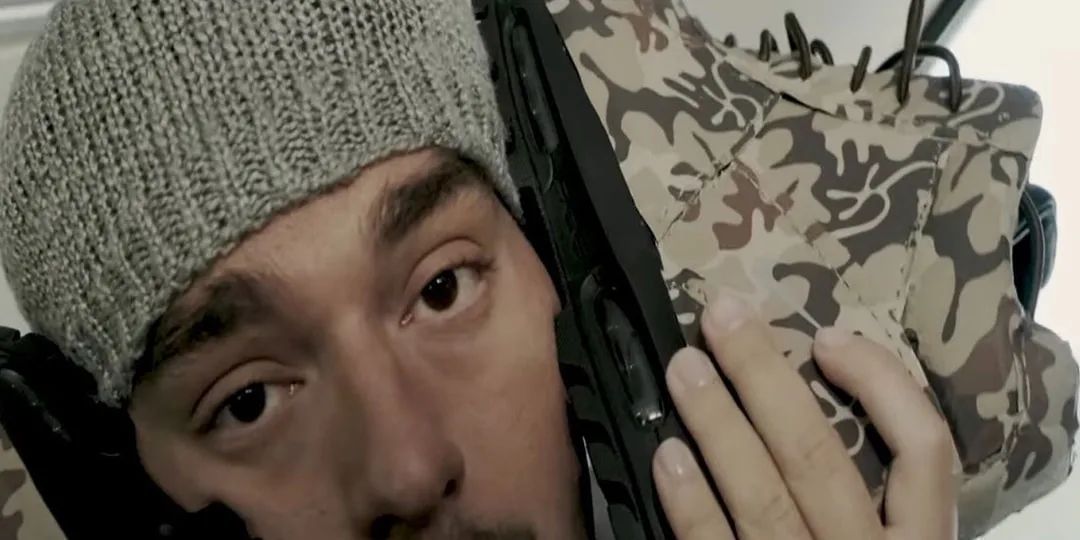 Homme portant un bonnet gris avec des chaussures camouflage.