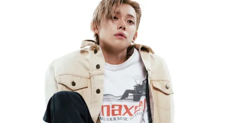 Homme avec veste beige et t-shirt blanc Maxell, pose décontractée.