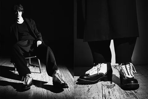 Homme en costume noir et bottes style retro.