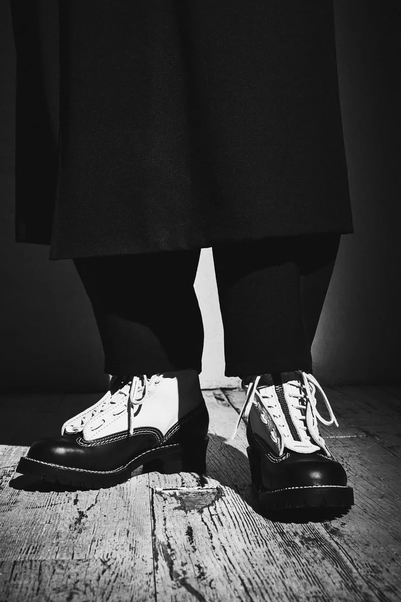 Chaussures blanches et noires sur plancher en bois.