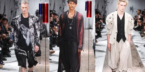 Trois mannequins défilant en vêtements de mode avant-gardiste sur un podium.