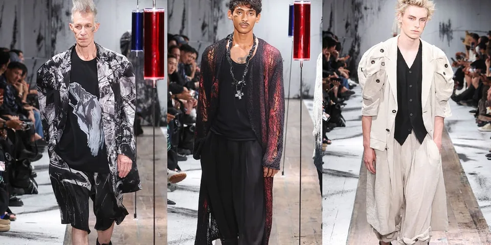 Trois mannequins défilant en vêtements de mode avant-gardiste sur un podium.