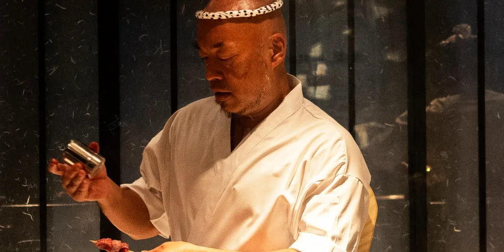 Chef en train de préparer un plat dans un restaurant japonais.