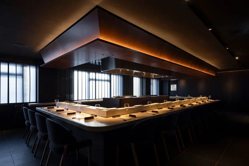 Intérieur d'un restaurant moderne avec un comptoir éclairé.