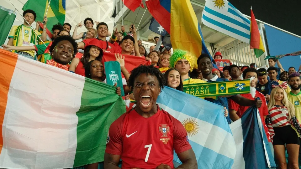Supporters de football avec drapeaux de divers pays, ambiance festive.