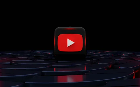 Cube noir et rouge avec logo de lecture YouTube sur fond sombre