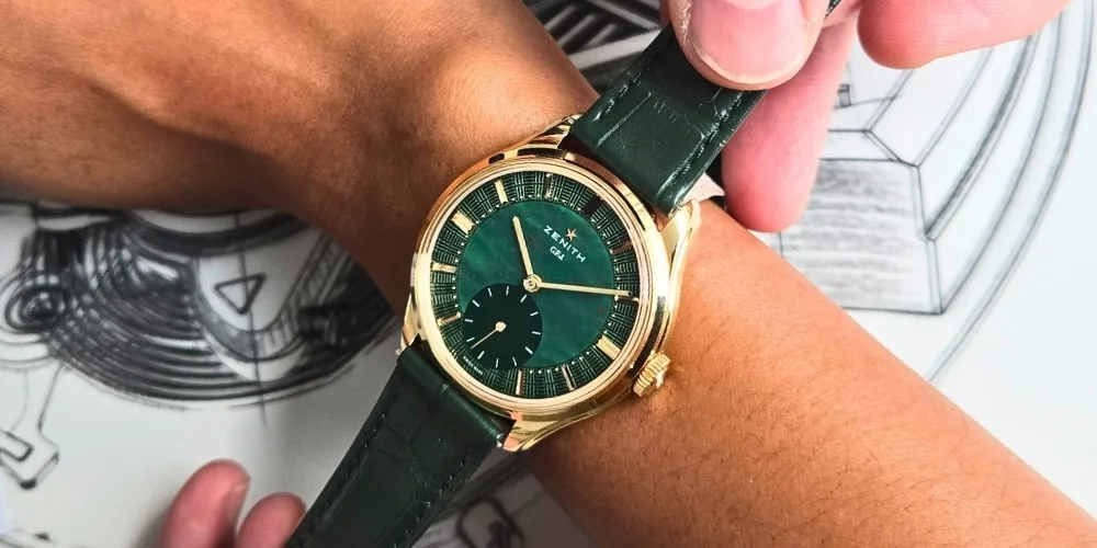 Montre-bracelet dorée avec cadran vert et bracelet en cuir vert.