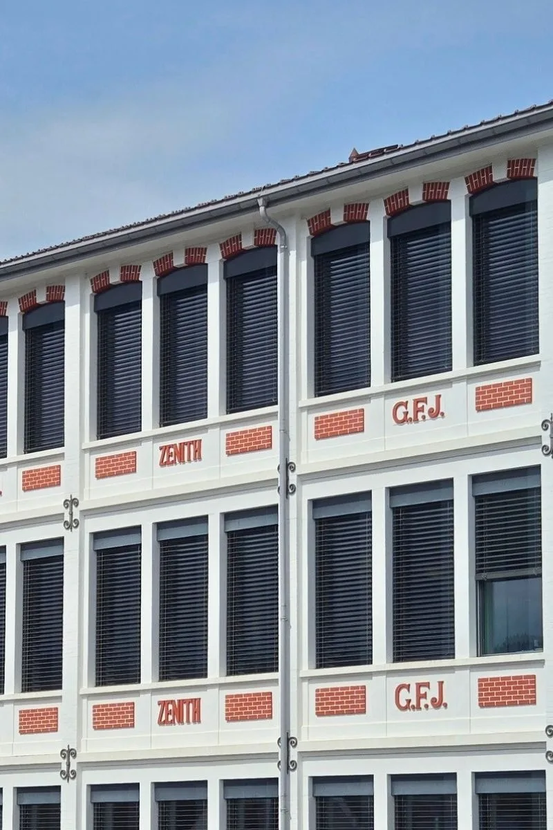 Façade d'un bâtiment avec les mots 'ZENITH' et 'G.F.J.' visibles sur les murs.