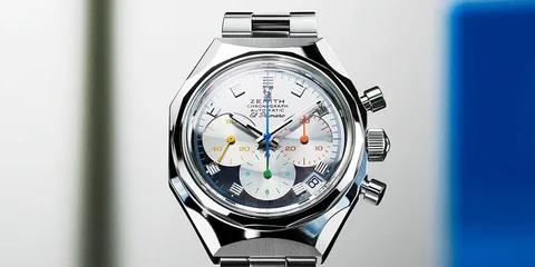 Montre chronographe en métal avec cadran multicolore et bracelet argenté.
