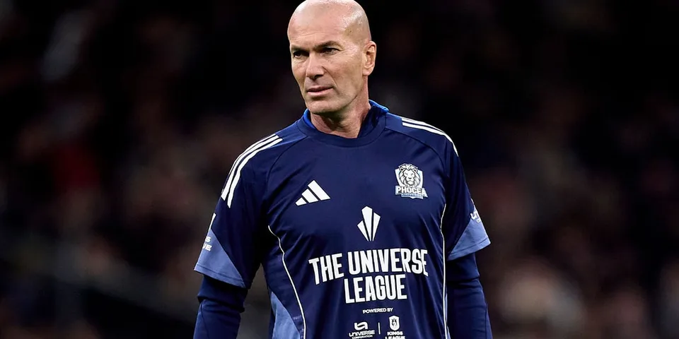 Homme chauve en maillot de football bleu sur le terrain.